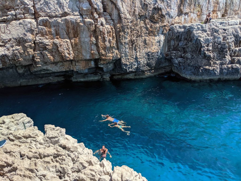 Swimmers enjoy the cool water after taking  the plunge from a nearby cliff - Odyssius Cave, Otok Mljet